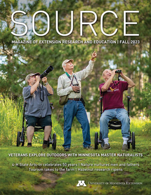 Cover of Source magazine featuring a photo of three men birdwatching.
