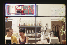 Open sign in a cafe with people