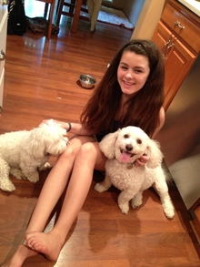 Youth with two white dogs on floor