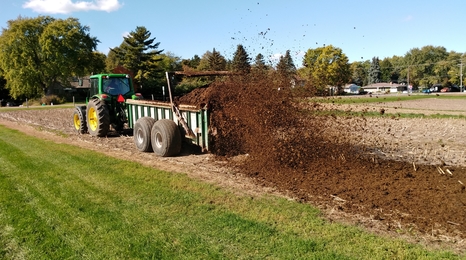Spreading manure in a field with a machine.