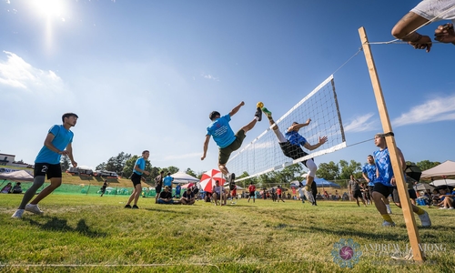  People playing in an outdoor volleyball match at the Hmong International Freedom Festival.
