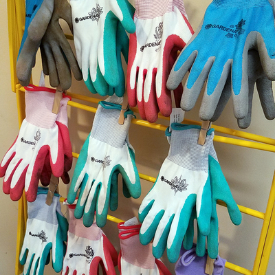 Rack of colored gardening gloves hanging to dry.