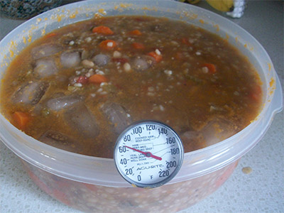 Cooling soup with thermometer.