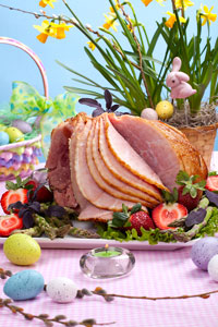Easter ham on platter with eggs around.