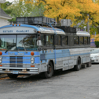 A blue and white bus parked on a city street