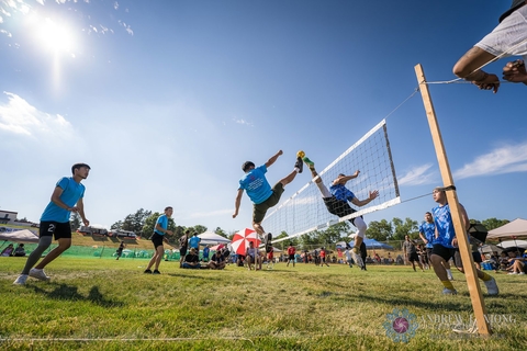 People playing in an outdoor volleyball match at the Hmong International Freedom Festival.