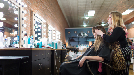 A person at a hair salon having a stylist do their hair.