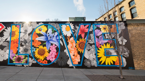 A mural of flowers with the word love in big letters on a building in Northfield, Minn.